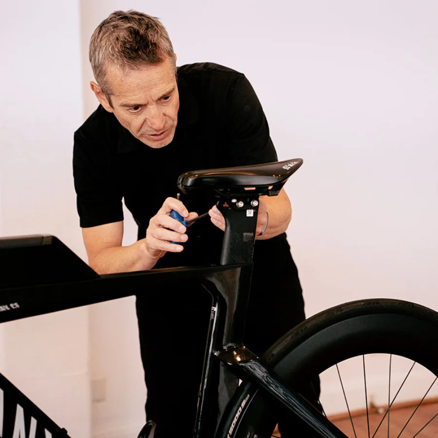Richard Melik making a precise saddle adjustment during a bike fit